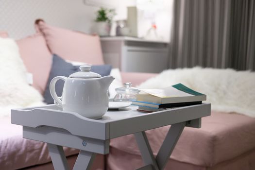 White teapot on the table in living room.