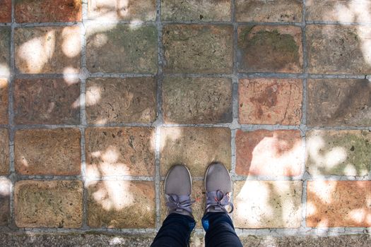 Top view of grey sneakers standing on concrete floor with copy space.