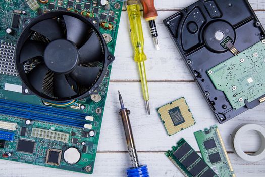 Computer motherboard, Computer Parts, Hard disk, Ram and equipment repair on the white wooden background.