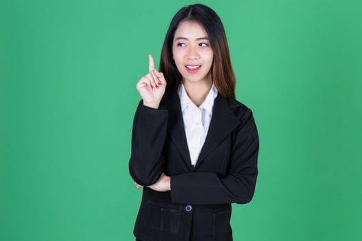 Portrait of attractive young Asian business woman having idea posing on green isolated background.