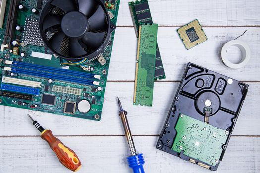 Computer motherboard, Computer Parts, Hard disk, Ram and equipment repair on the white wooden background.