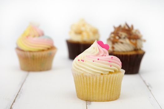 Cupcakes are beautifully decorated in clear lighting, AF point selection.