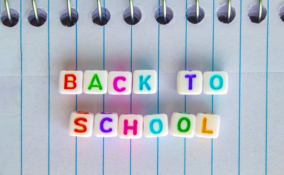 Back to School, message in colorful text on white cubes on a notebook