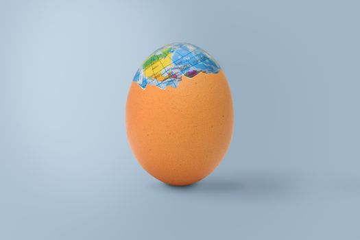 The shelled egg has an globe inside. Easter concept.