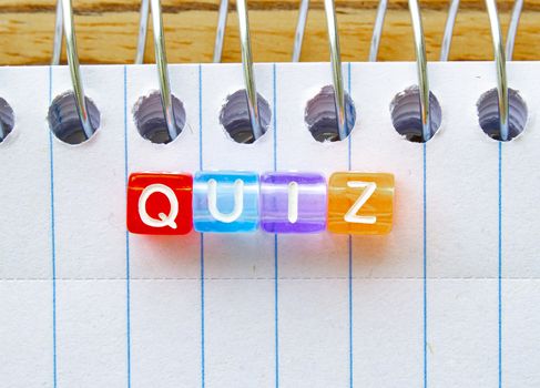 Quiz, message in text on colorful cubes on a notebook