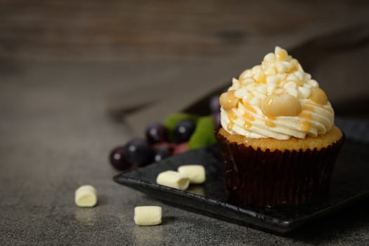 Cupcakes are beautifully decorated in Dark lighting, AF point selection.