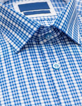 blue shirt with checkered pattern and with a focus on the collar and button, close-up