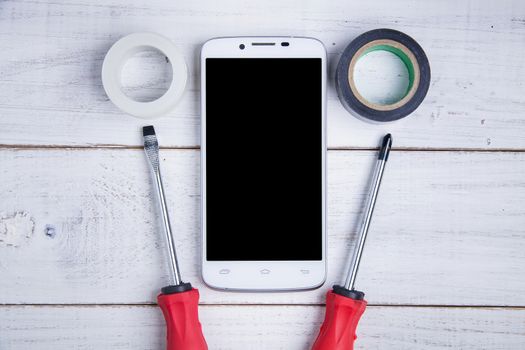 smartphone and equipment repair on the white wooden background