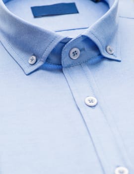 blue shirt with a focus on the collar and button, close-up