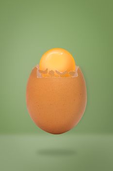 Contemporary art-Egg shell with yellow yolk on green background with copy space, Minimal idea style.