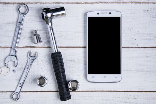 smartphone and equipment repair on the white wooden background