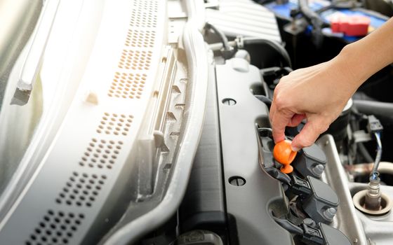 The car is opening the hood to check the engine oil.