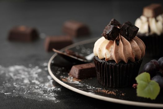 Chocolate cupcake with icing and chocolate bar in Dark lighting, AF point selection.