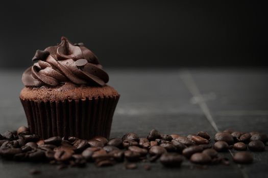 Chocolate cupcakes with coffee beans on dark background, AF point selection.