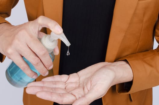 Closeup of man using wash hand sanitizer gel pump dispenser, Hygiene and Covid-19 virus protection concept