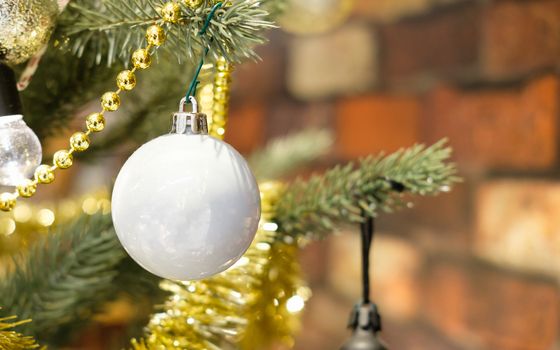 Closeup of Glitter Ball hanging from a decorated Christmas tree. Retro filter effect, AF point selection.