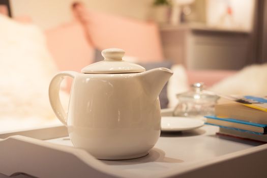 White teapot on the table in living room. vintage tone. Afternoon sun.