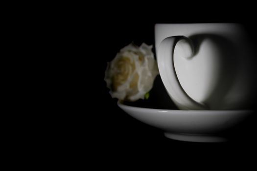 Hot coffee in white ceramic cup with shiny heart shadow, with copy space to write. Valentine concept.