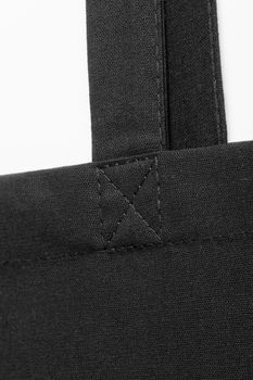 close-up of the sewing seam on the black fabric handle of the bag