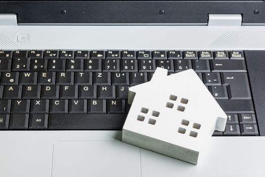 wooden white hose model on laptop notebook.Online shopping concept.Real estate concept, New house concept.Buying a house.