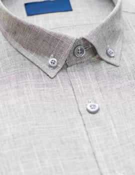 gray shirt with a focus on the collar and button, close-up