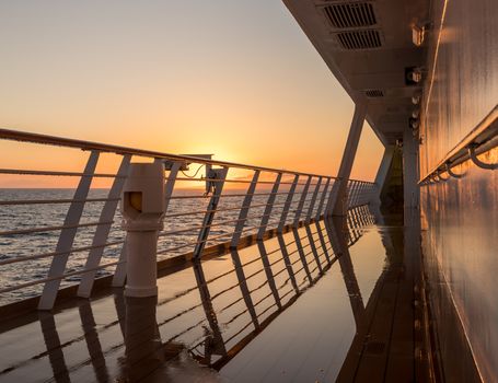 Deck on small cruise liner sailing across the ocean as the sun rises