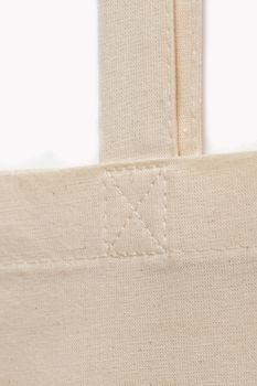 close-up of the sewing seam on the white fabric handle of the bag