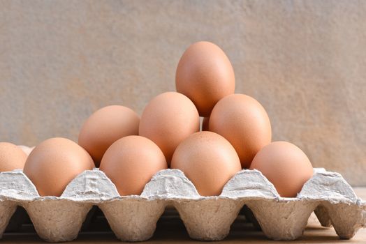 Egg, Chicken Egg. Close-up view of raw Brown chicken eggs in egg box on Cement floor background. Selected focus