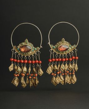 ancient antique earrings with stones on black background. Middle-Asian vintage jewelry