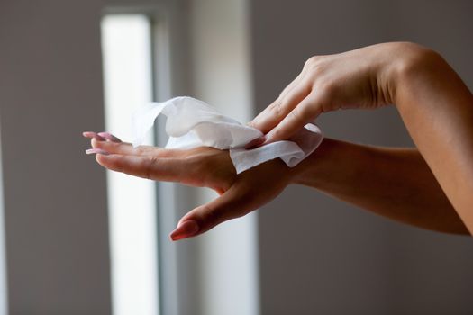 Young woman clean hands with wet wipes