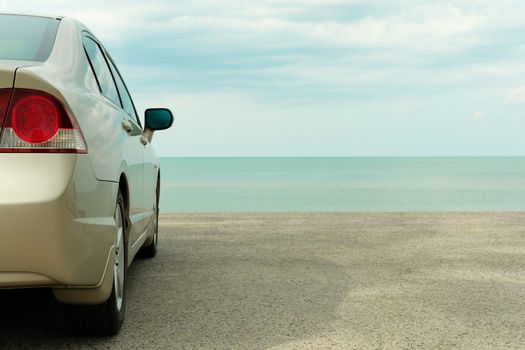 Golden car parked at the blue sea. Vintage picture.