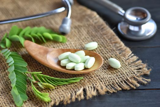 Herbal medicine from Tamarind leaves on rustic black wooden table with copy space for medical background, healthy eating with natural product for good living. Medicine concepts. Selected focus