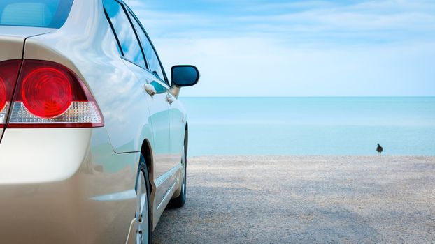 Golden car parked at the blue sea.