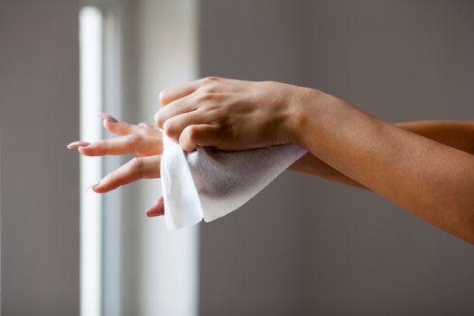 Young woman clean hands with wet wipes