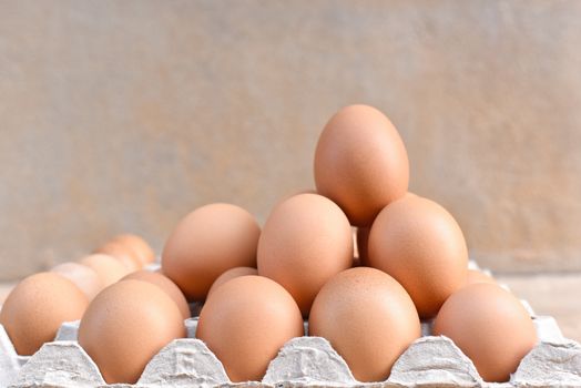 Egg, Chicken Egg. Close-up view of raw Brown chicken eggs in egg box on Cement floor background. Selected focus