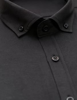 black shirt with a focus on the collar and button, close-up