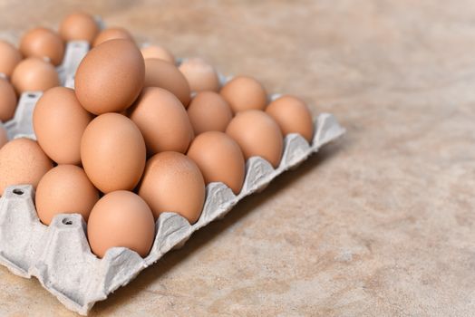 Egg, Chicken Egg. Close-up view of raw Brown chicken eggs in egg box on Cement floor background. Selected focus