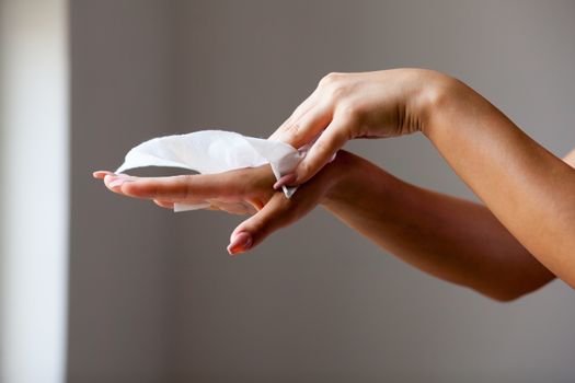 Young woman clean hands with wet wipes