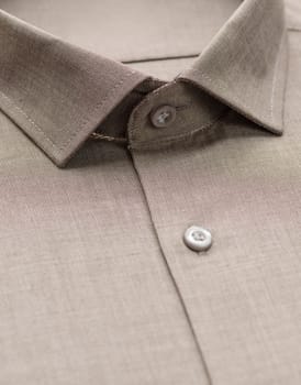 brown shirt with focus on collar and button, close-up