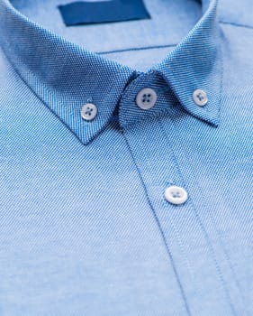 blue shirt with focus on collar and button, close-up