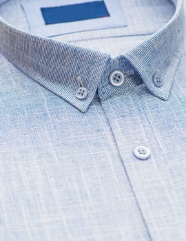 blue shirt with focus on collar and button, close-up