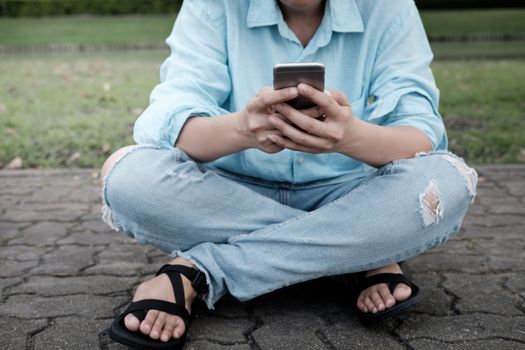 Hand's young hipster woman using smart phone on brick road.