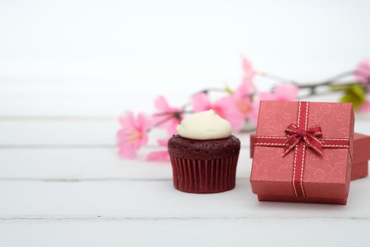 Gift box and cupcake on whie table background with copy space to write.