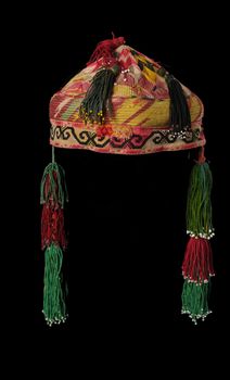 colorful traditional asian skullcap hat with pigtails on a dark background