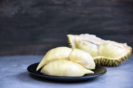 Durian riped. King of Fruits. Durian is a popular tropical fruit in Thailand. Betel of durian on black dish with durian peel on Dark color background. Seasonal fruit concept. Selected focus.