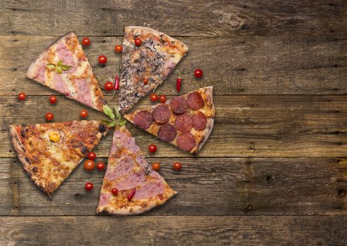 Italian food - pizza on wooden table. Cherry tomato and hot peppers around