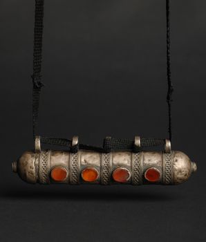 ancient antique pendant with stones on black background. Middle-Asian vintage jewelry