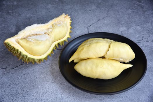 Durian riped. King of Fruits. Durian is a popular tropical fruit in Thailand. Betel of durian on black dish with durian peel on Dark color background. Seasonal fruit concept. Selected focus.