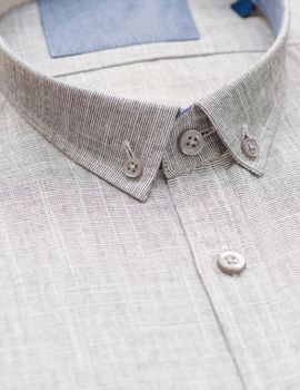 gray shirt with a focus on the collar and button, close-up