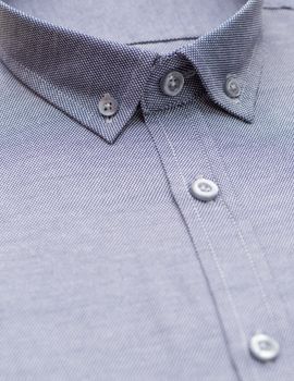 blue shirt with a focus on the collar and button, close-up